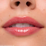 Lips coated in Keepin’ It Sweet Ultra Glossy Lip (ColourPop Ultra Glossy Lip) gleam with a sheer pink, glassy finish in a tight close-up, highlighting smooth texture and shine around the mouth.