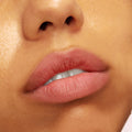 Softly tinted lips wearing Mood 24/7 from the ColourPop Cheek & Lip Set, showing a rosy nude, blurred-matte finish as the mouth gently parts, captured in an extreme close-up against dewy skin for a natural everyday look.