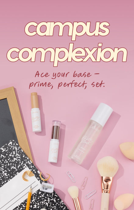 reolink.liveplexion essentials arranged in a flat lay - concealer, primer, and setting spray - paired with makeup brushes, paper clips, and a composition notebook on a pink background with the headline “campus complexion” for back‑to‑school.