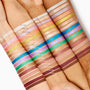 Walnut Ave Shadow Stix swatch - rich walnut-brown matte - striped across light, medium, and deep skin beside other shades, showing smooth payoff and depth; ColourPop Shadow Stix cream eyeshadow in a deep neutral brown.