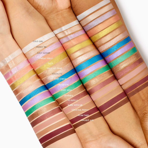 ColourPop Shadow Stix Rain Check swatched as a vivid cobalt-blue metallic stripe across three arms in varied skin tones, highlighting the creamy, one-swipe payoff of this twist-up eyeshadow stick amid assorted shade swatches.