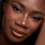 Gone Metal ColourPop Shadow Palette creates a smoky metallic taupe eye on a model, with blended shimmer and soft winged liner, shown in a tight beauty close-up with warm blush and glossy bronze lips under studio lighting.
