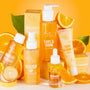 Colourful orange display of Colourpop Fourth Ray serums and Ego Boost serum stick standing among fresh orange slices on a bright citrus background, highlighting the vibrant skincare collection for glowing skin in the US.