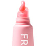 ColourPop Fresh Kiss Glossy Balm in Strawberry Milk forming a glossy milky-pink droplet on its slanted applicator as it emerges from a pastel pink squeeze tube, macro close-up on a clean white studio background.