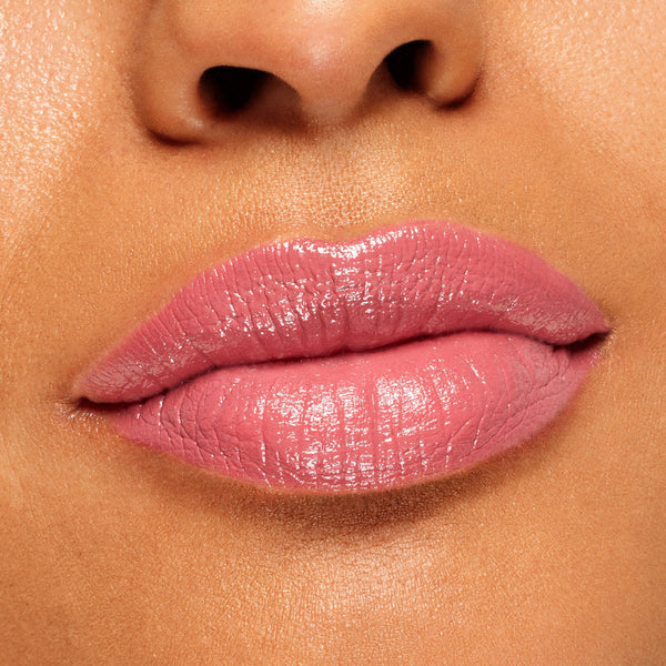 Glossy lips wear ColourPop Lippie Stix in Felt Cute, a soft pink shade applied evenly with a creamy, high-shine finish, shown in an extreme close-up lip swatch for color and texture detail.