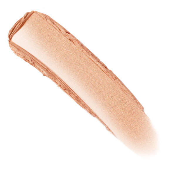 Molten Hot ColourPop Lite Stix swatch streak - creamy, shimmery peachy-gold highlighter - swept diagonally across a white background, showing blendable sheen and smooth texture.