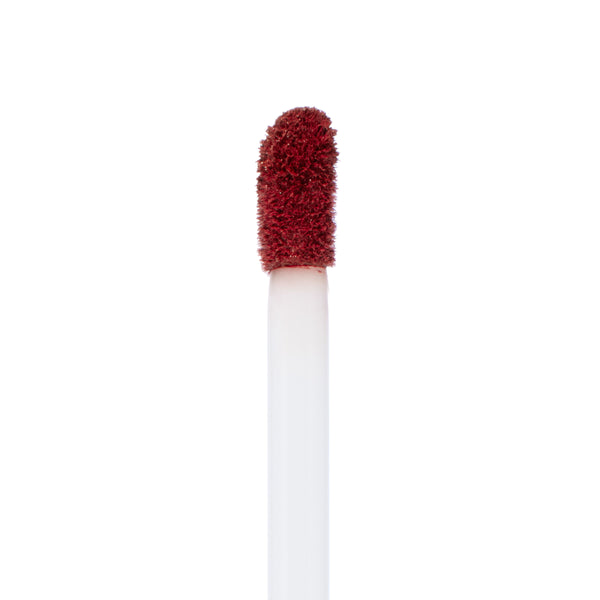 Doe-foot applicator coating deep brick red Off The Record Ultra Matte Lip, shown close-up against a white background, highlighting velvety pigment and precise tip from ColourPop Ultra Matte Lip collection.