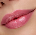 Glossy lips wearing Transform pH lip balm, showing a sheer rosy pink tint that deepens at the edges in a close-up swatch; ColourPop pH Lip Balm delivers pH‑reactive color and a hydrated, glassy finish.