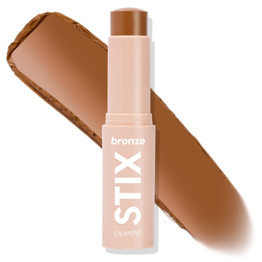 ColourPop Bronzer Stix in Rincon Point stands uncapped in a nude‑pink twist‑up tube marked STIX, with a warm caramel‑brown cream bullet and a diagonal swatch showing smooth payoff on a white background.