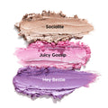 Three ColourPop Shadow Stix Cool Metallics swatches streak across a white background - Socialite (shimmery champagne), Juicy Gossip (metallic pink), and Hey Bestie (lavender purple) - showing creamy, high-shine payoff.