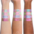Colourpop Shadow Stix Game Over swatched on three skin tones, showing the shimmery pink-to-green duochrome strip labeled Game Over between Disco Disco and Cotton Candy shades on each forearm for comparison.