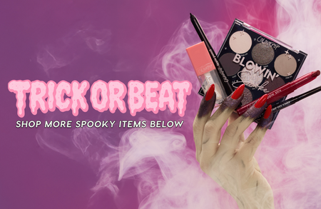 Glamorous spooky hand with long red nails holds Colourpop eyeshadow palette, lip products, and eyeliner against pink smoky background with “Trick or Beat” Halloween promo text, advertising Colourpop makeup for a Halloween look in the US.