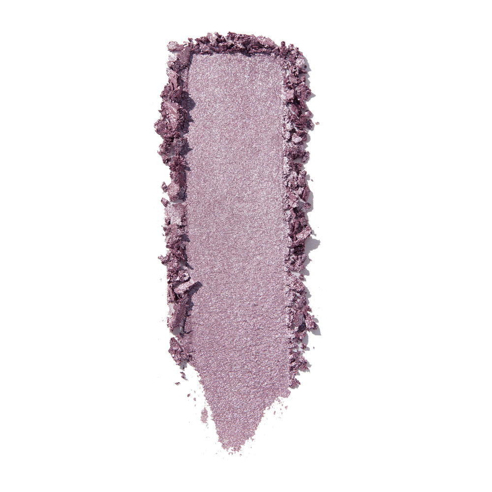 The Griffith Super Shock Shadow by ColourPop swatched in a single vertical swipe, a cool-toned lilac-mauve with silver sparkle and metallic sheen, creamy texture with crumbled edges, on a bright white background.