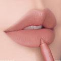 Cool Besties ColourPop Lippie Pencil lining soft matte lips in a cool-toned nude shade, the tip gliding along the lower lip for precise definition in a close-up studio beauty shot.