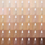 ColourPop Hyaluronic Hydrating Foundation Pretty Fresh bottle in shade Light 50 W displayed within a full shade grid from fair to deep tones, frosted pump with white cap on warm nude tiles.