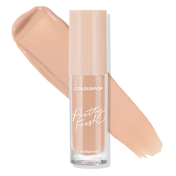 ColourPop Pretty Fresh Creamy Concealer in Medium 105 N stands upright, its frosted clear tube with blush cap and white script logo set before a smooth warm neutral beige swatch, highlighting the hyaluronic creamy formula on a white background.