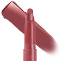 ColourPop Lippie Stix in shade Happy Thoughts stands upright with the rounded bullet exposed, a rosy mauve swatch streaked diagonally behind it on a white background, highlighting the creamy lip color in a slim twist-up tube.
