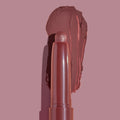 Plum Tart ColourPop Shadow Stix eyeshadow, uncapped with a twist-up tip beside a broad matte plum swatch on a mauve background, showcasing creamy texture and rich pigment.