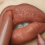 ColourPop Lippie Pencil Field Day lining full lips in a warm terracotta nude, pencil tip tracing the lower lip while a matching lippie touches the upper lip, close-up beauty shot highlighting creamy, precise application.