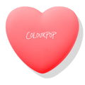 Heart-shaped coral compact shows the ColourPop logo, Woo Me pressed powder blush closed and ready to open, set on a white background with soft shadow; ColourPop Pressed Powder Blush in pink-red case.